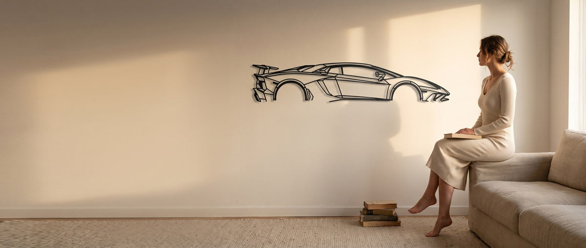 A woman hanging a matte black laser-cut steel car silhouette on a wall at home