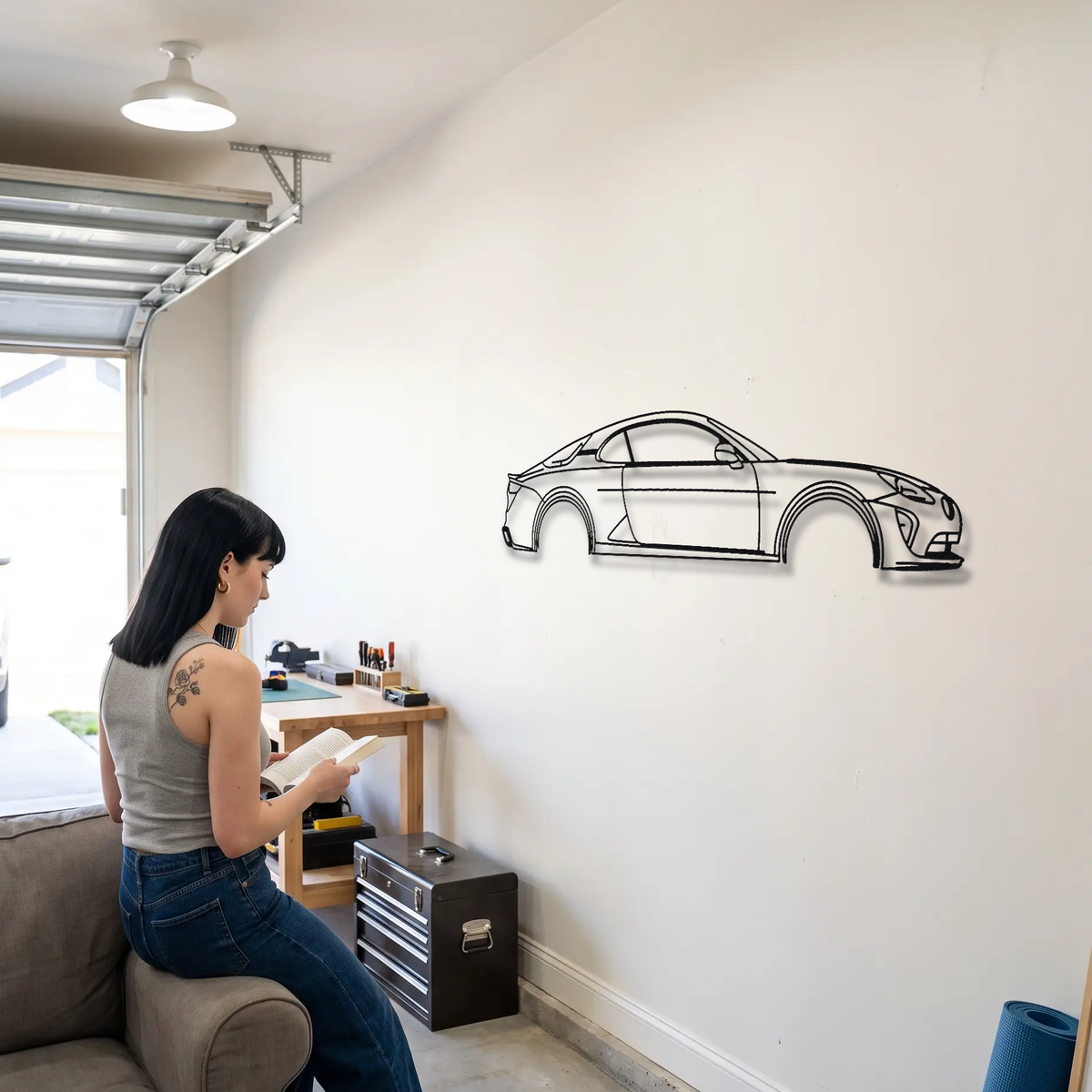 Alpine A110 R metal wall art shown to scale beside a person