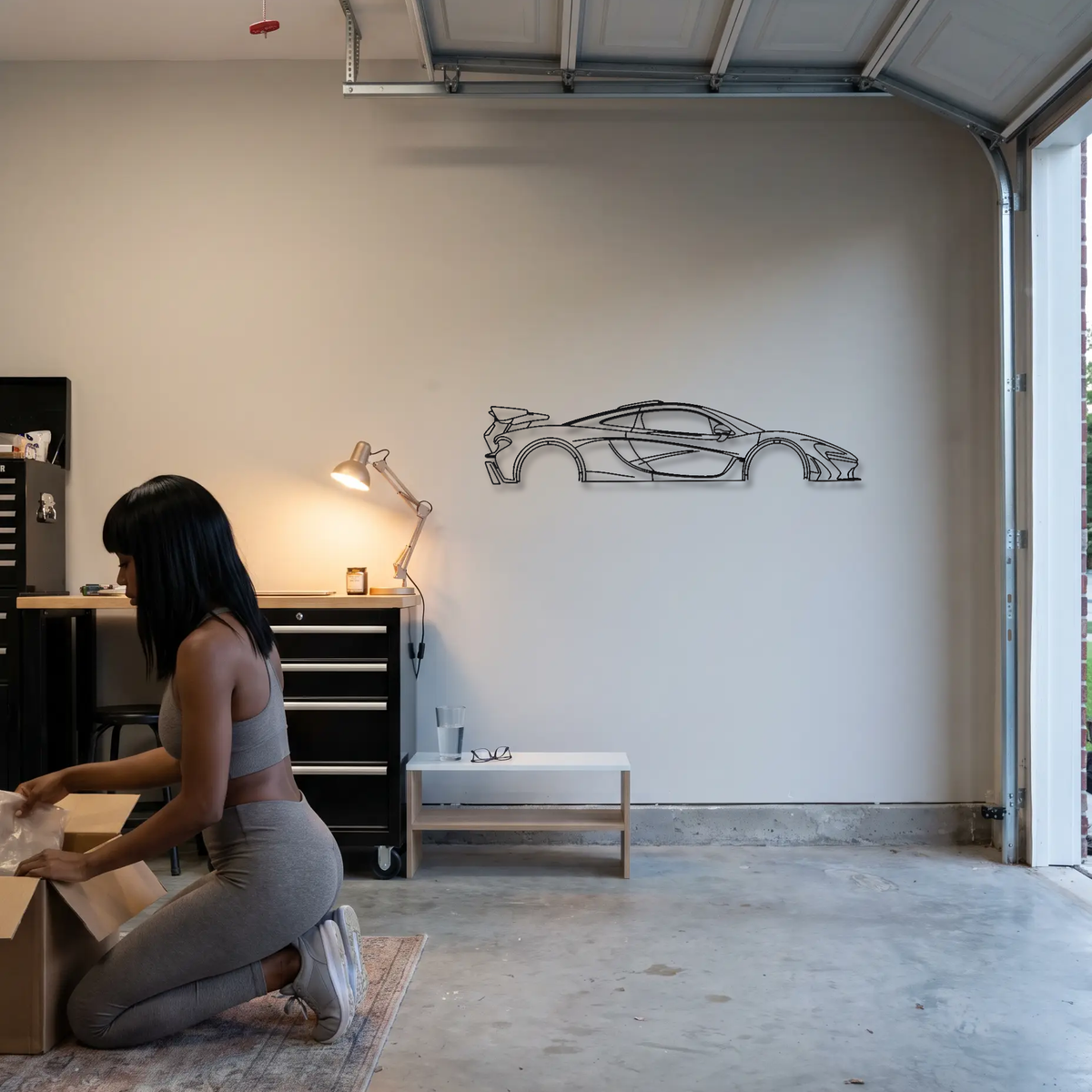 McLaren P1 LM metal wall art shown to scale beside a person
