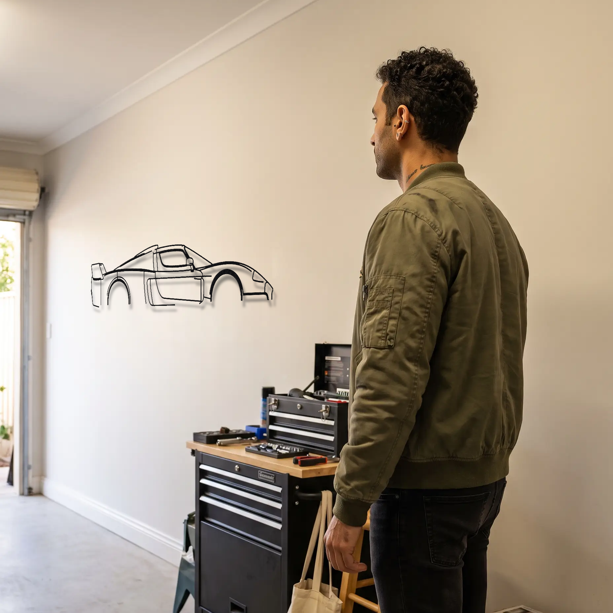 Maserati MC12 metal wall art shown to scale beside a person