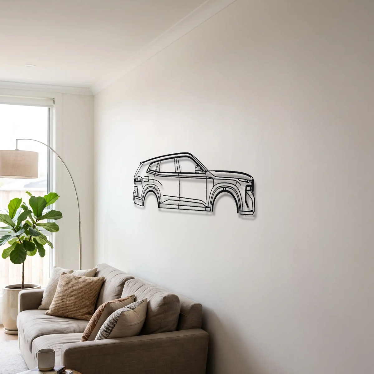 BMW XM G09 metal wall art above a sofa in a living room